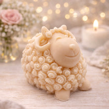 Load image into Gallery viewer, handmade vegan soap in the shape of a realistic smiling ram with curved horns and detailed curly wool texture, displayed on a rustic wooden surface with lavender and white flowers.