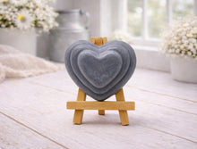 Load image into Gallery viewer, handmade vegan soap gift featuring a triple-tiered heart relief design, displayed on a wooden easel against a rustic farmhouse decor background with lavender.