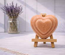 Load image into Gallery viewer, handmade vegan soap gift featuring a triple-tiered heart relief design, displayed on a wooden easel against a rustic farmhouse decor background with lavender.