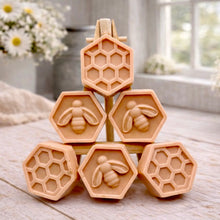 Load image into Gallery viewer, A handmade vegan soap gift set featuring six hexagonal bars stacked in a pyramid on a small wooden easel; some bars show a honeybee relief and others a honeycomb pattern