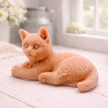 Load image into Gallery viewer, A highly detailed handmade vegan soap sculpted in the shape of a sitting cat with its tail curled around its paws, featuring realistic fur texture and a sweet facial expression, displayed on a light wooden surface.