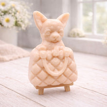 Load image into Gallery viewer, A highly detailed handmade vegan soap in a speckled grey marble finish, sculpted as a small chihuahua puppy with large ears peeking out from inside a quilted designer-style handbag, displayed on a miniature wooden easel.