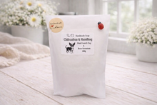 Load image into Gallery viewer, White soap bar with a label on a wooden surface, surrounded by flowers.