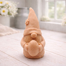 Load image into Gallery viewer, A detailed handmade vegan soap gift, sculpted as a whimsical Easter gnome (gonk) wearing a tall pointed hat with a flower detail, holding a large patterned Easter egg.