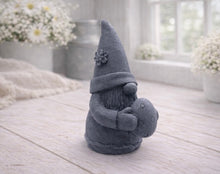 Load image into Gallery viewer, A detailed handmade vegan soap gift, sculpted as a whimsical Easter gnome (gonk) wearing a tall pointed hat with a flower detail, holding a large patterned Easter egg.