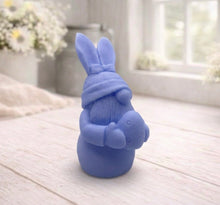 Load image into Gallery viewer, A detailed handmade vegan soap in a natural colour, sculpted as a whimsical Easter gnome (gonk) with long rabbit ears and a bow on its hat, holding a patterned Easter egg, displayed on a light wooden surface. Easter gift