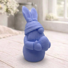 Load image into Gallery viewer, A detailed handmade vegan soap in a natural colour, sculpted as a whimsical Easter gnome (gonk) with long rabbit ears and a bow on its hat, holding a patterned Easter egg, displayed on a light wooden surface. Easter gift