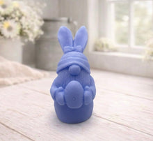 Load image into Gallery viewer, A detailed handmade vegan soap in a natural colour, sculpted as a whimsical Easter gnome (gonk) with long rabbit ears and a bow on its hat, holding a patterned Easter egg, displayed on a light wooden surface. Easter gift