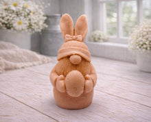 Load image into Gallery viewer, A detailed handmade vegan soap in a natural colour, sculpted as a whimsical Easter gnome (gonk) with long rabbit ears and a bow on its hat, holding a patterned Easter egg, displayed on a light wooden surface. Easter gift