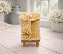 Load image into Gallery viewer, A rectangular handmade vegan soap featuring a detailed relief of a winged fairy reaching towards a butterfly in a meadow of tall grass and flowers, displayed on a miniature wooden easel