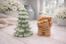 Load image into Gallery viewer, A duo of handmade vegan soaps featuring a Father Christmas figure with standing next to a mint-green tiered 3D Christmas tree, displayed in a bright farmhouse setting.