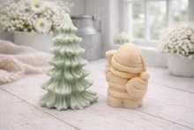 Load image into Gallery viewer, A duo of handmade vegan soaps featuring a Father Christmas figure with standing next to a mint-green tiered 3D Christmas tree, displayed in a bright farmhouse setting.