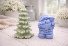 Load image into Gallery viewer, A duo of handmade vegan soaps featuring a Father Christmas figure with standing next to a mint-green tiered 3D Christmas tree, displayed in a bright farmhouse setting.
