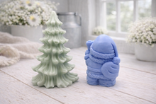 Load image into Gallery viewer, A duo of handmade vegan soaps featuring a Father Christmas figure with standing next to a mint-green tiered 3D Christmas tree, displayed in a bright farmhouse setting.
