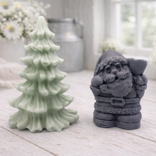Load image into Gallery viewer, A duo of handmade vegan soaps featuring a Father Christmas figure with standing next to a mint-green tiered 3D Christmas tree, displayed in a bright farmhouse setting.