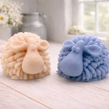 Load image into Gallery viewer, A highly detailed handmade vegan soap sculpted in the shape of a fluffy sheep with thick, textured wool and a smooth face, displayed on a light wooden surface in a farmhouse-style setting.