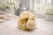 Load image into Gallery viewer, A highly detailed handmade vegan soap sculpted in the shape of a fluffy sheep with thick, textured wool and a smooth face, displayed on a light wooden surface in a farmhouse-style setting.