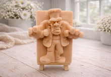 Load image into Gallery viewer, A rectangular handmade vegan soap featuring a high-relief carving of Frankenstein's monster in a classic pose with arms outstretched and a grumpy expression, displayed on a miniature wooden easel.
