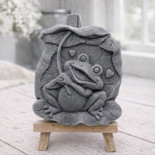 Load image into Gallery viewer, A rectangular handmade vegan soap featuring a high-relief carving of a cheerful, smiling frog sitting on a large lilypad and holding the stem of a leaf over its head like an umbrella.