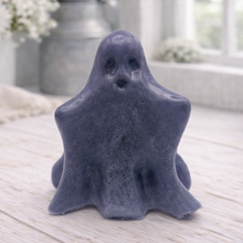 Load image into Gallery viewer, A handmade vegan soap shaped like a friendly ghost with a surprised expression, sitting on a light wood surface with white daisies in the background