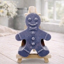 Load image into Gallery viewer, A handmade vegan featuring a classic gingerbread man with a smiling face, a bow tie, and decorative icing details on his arms and legs, displayed on a miniature wooden easel.