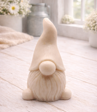 Load image into Gallery viewer, A handmade vegan soap sculpted in the shape of a charming gnome (or gonk), featuring a tall, pointed hat pulled down over the eyes and a full, textured beard, in a natural cream colour.