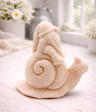 Load image into Gallery viewer, A handmade vegan soap gift, sculpted as a whimsical gnome (gonk) with a tall, slouchy hat and a long beard, sitting on the shell of a large snail with a textured, bumpy body.