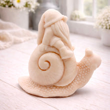 Load image into Gallery viewer, A handmade vegan soap gift, sculpted as a whimsical gnome (gonk) with a tall, slouchy hat and a long beard, sitting on the shell of a large snail with a textured, bumpy body.