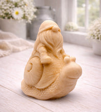 Load image into Gallery viewer, A handmade vegan soap gift, sculpted as a whimsical gnome (gonk) with a tall, slouchy hat and a long beard, sitting on the shell of a large snail with a textured, bumpy body.