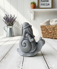 Load image into Gallery viewer, A handmade vegan soap gift, sculpted as a whimsical gnome (gonk) with a tall, slouchy hat and a long beard, sitting on the shell of a large snail with a textured, bumpy body.
