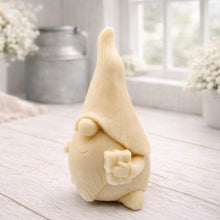 Load image into Gallery viewer, A cream-coloured handmade vegan soap sculpted as a tall, whimsical gnome (gonk) with a pointed hat and long beard, featuring a natural twine hanging rope at the top and displayed in a bright farmhouse setting.
