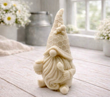 Load image into Gallery viewer, A handmade vegan soap in the shape of a gnome with a long beard, wearing a honeycomb-patterned hat with a bee, holding a honey pot and dipper.