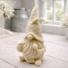 Load image into Gallery viewer, A handmade vegan soap in the shape of a gnome with a long beard, wearing a honeycomb-patterned hat with a bee, holding a honey pot and dipper.