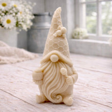 Load image into Gallery viewer, A handmade vegan soap in the shape of a gnome with a long beard, wearing a honeycomb-patterned hat with a bee, holding a honey pot and dipper.