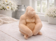 Load image into Gallery viewer, A highly detailed handmade vegan soap in a natural colour, sculpted in the shape of a sitting gorilla with realistic fur and muscle textures, displayed on a light wooden surface.
