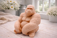 Load image into Gallery viewer, A highly detailed handmade vegan soap in a natural colour, sculpted in the shape of a sitting gorilla with realistic fur and muscle textures, displayed on a light wooden surface. Gift boxed.