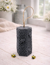 Load image into Gallery viewer, A tall, rectangular handmade vegan soap with a detailed honeycomb texture on all sides and small embossed bees, featuring a natural twine hanging rope, displayed upright on a light wooden surface.