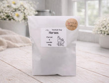 Load image into Gallery viewer, Handmade soap package labeled 'Horses' with charcoal and lavender scent on a wooden surface.