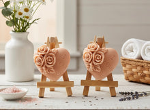 Load image into Gallery viewer, Two handmade heart vegan soaps by Soap Simple Creations, embossed with "I Love U" and detailed roses, displayed on wooden easels in a rustic farmhouse decor setting.