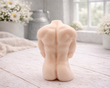 Load image into Gallery viewer, A 3D handmade vegan soap sculpted into a detailed male torso with defined chest and abdominal muscles, finished in a soft tone and displayed in a bright farmhouse setting.