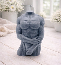 Load image into Gallery viewer, A 3D handmade vegan soap sculpted into a detailed male torso with defined chest and abdominal muscles, finished in a soft tone and displayed in a bright farmhouse setting.