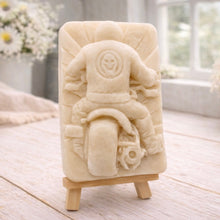 Load image into Gallery viewer, detailed handmade vegan soap gift featuring a motorcycle rider with a skull emblem on their jacket, displayed on a wooden easel against a whimsical farmhouse decor background