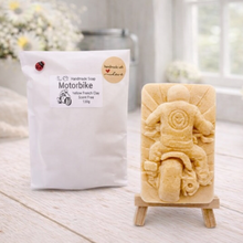 Load image into Gallery viewer, Handmade soap shaped like a motorcycle on a stand with packaging labeled 'Motorbike' in a bright setting.