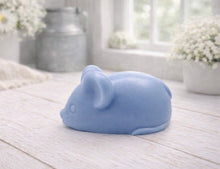Load image into Gallery viewer, A 3D handmade vegan soap sculpted into the shape of a cute resting mouse with large rounded ears and a delicate snout, displayed on a light wooden surface in a bright farmhouse setting