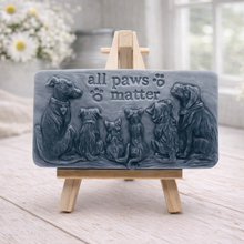 Load image into Gallery viewer, A rectangular handmade vegan soap bar gift, featuring a detailed relief carving of several dogs and a cat sitting together, with the words "all paws matter" and two paw prints embossed at the top, displayed on a wooden easel. Made in Blackpool.