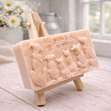 Load image into Gallery viewer, A rectangular handmade vegan soap bar gift, featuring a detailed relief carving of several dogs and a cat sitting together, with the words "all paws matter" and two paw prints embossed at the top, displayed on a wooden easel. Made in Blackpool.