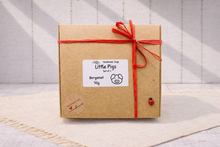 Load image into Gallery viewer, Kraft paper gift box with red ribbon and 'Little Pigs' label on a textured surface.