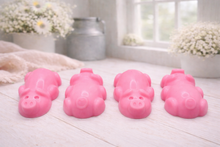Load image into Gallery viewer, A charming collection of four handmade vegan soaps featuring four piglets, each intricately sculpted with realistic textures and playful expressions, arranged on a light wooden surface.