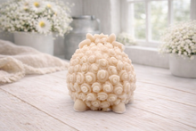 Load image into Gallery viewer, A highly detailed handmade vegan soap sculpted in the shape of a sturdy ram with a thick coat of tight, curly wool and large, elegant curved horns, displayed on a light wooden surface in a bright farmhouse setting.