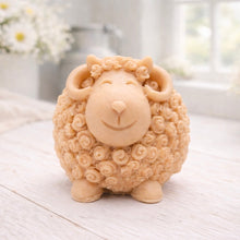 Load image into Gallery viewer, A highly detailed handmade vegan soap sculpted in the shape of a sturdy ram with a thick coat of tight, curly wool and large, elegant curved horns, displayed on a light wooden surface in a bright farmhouse setting.